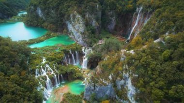 Şelale sonbahar ormanlarındaki birçok dereye akar ve göle akar. Parlak taze zümrüt suyu. Hırvatistan 'daki Plitvice Gölü Ulusal Parkı. Şelalenin havadan görünüşü ve parlak tatlı su