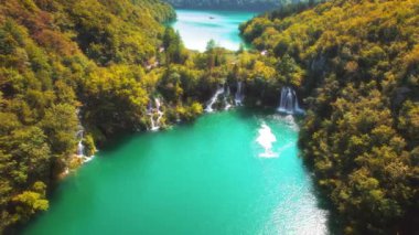 Sonbahar günü, dağ ormanlarındaki şelale dereleri, sarı ağaçlar ve parlak turuncu yapraklar. Plitvice gölündeki zümrüt yeşili su Hırvatistan 'daki Ulusal Parkı sular altında bıraktı.