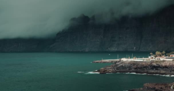 浓密的灰云笼罩在漆黑的大海中的巨石上 暴风雨前的天气位于西班牙加那利群岛洛根提斯悬崖的火山岛Tenerife 海景上的闷热天空 — 图库视频影像