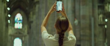 İtalya 'da şehir turu sırasında telefonuyla fotoğraf çeken bir kadın. Antik bir binanın mimarisi. Turist müzede fotoğraf çekiyor..