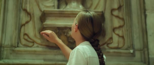 女人的手触摸着教堂的古城墙 历史建筑 女孩的特写 艺术研究 祈祷者的礼仪和感情 — 图库视频影像