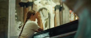 Kilise cemaatinden bir kız katedralde diz çöküp dua ediyor. Tanrı 'yla konuşan samimi, inançlı bir kadın. Günahların affı.