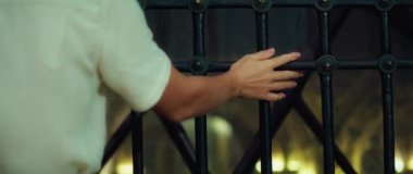 Yakın plan kadınlar metal parmaklıklara dokunur, kadın parmakları ızgara boyunca koşar. Daldırma gezisi.