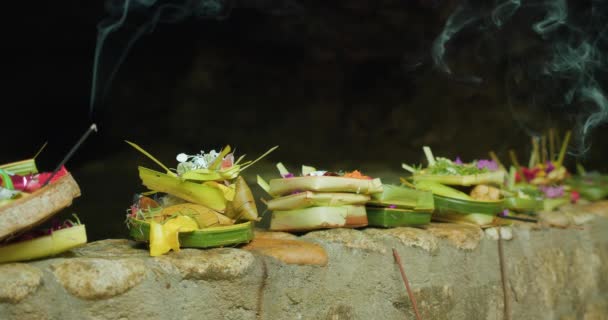 カナンサリは毎日 ヒヤン ウィディ ワサに賞賛と祈りに感謝するために バリンス ヒンドゥー教徒によって作られたオファーを提供しています インドネシアのバリ島の花のバスケットと焼香の棒 — ストック動画