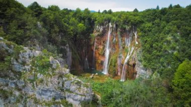Güçlü şelale masmavi berrak suyla bir göle akar. Hırvatistan 'daki Plitvice Lakes Ulusal Parkı. Şelaleler ve kireçtaşı kanyonuyla birbirine bağlı 16 gölden oluşan bir şelale. Hava görünümü.