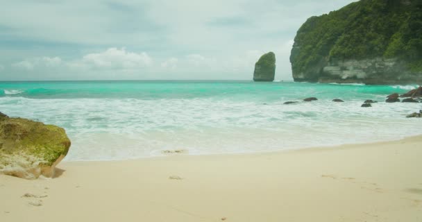 在未被破坏的沙滩上起泡的海浪 绿松石海水近距离慢速运动 遥远的异国他乡印度尼西亚努沙佩尼达巴厘的泰姆林海滩和森林 — 图库视频影像