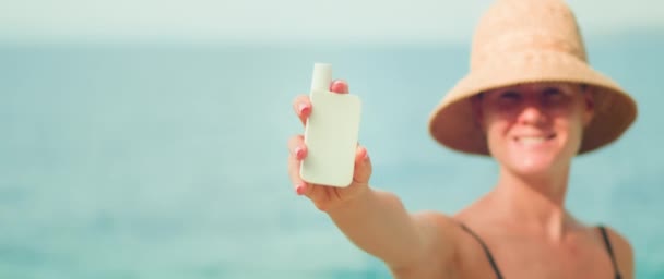 Vrouw Demonstreren Witte Buis Van Zonnebrandcrème Huidverzorging Crème Oceaan Achtergrond — Stockvideo
