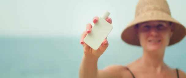 在洋底展示白色防晒霜管的女人 女孩有选择地把焦点放在化妆品上 手里拿着一个罐子 在镜头前展示 — 图库视频影像