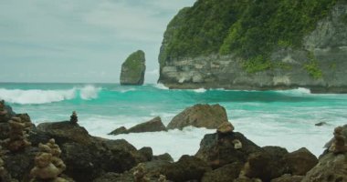 Tembeling Sahili 'ndeki okyanus manzarası. Dalgalar kayalıklara çarpar. Tropik ada Nusa Penida, Bali, Endonezya. Fırtınalı denizin turkuaz suyu. Yakın plan..