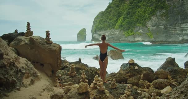 Una Donna Con Braccia Spalancate Erge Una Spiaggia Rocciosa Fronte — Video Stock