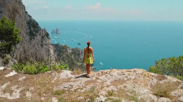 从上方俯瞰卡彭风景 女人凝视着岩石边浩瀚的大海 凝视着下面的法拉格洛尼悬崖 意大利假日 — 图库视频影像