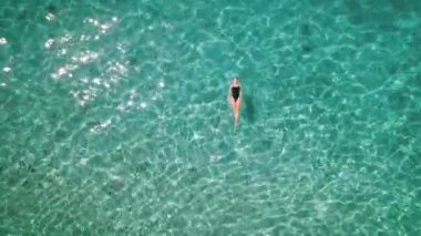 Temiz, ışıl ışıl sularda yüzen bir kadın figürü. Ruhsal deniz güneşin altında parlıyor, huzur verici bir tefekküre yol açıyor...
