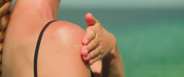 适用于妇女肩部的防晒霜 以大海为背景的作用 产品的使用以及保护皮肤不受太阳光照射的重要性 — 图库视频影像