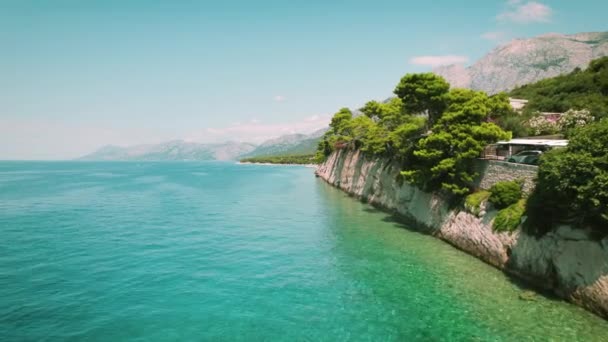 海滨悬崖拥抱蓝色的水 茂密的绿叶盖住了耸立在平静的亚得里亚海水面上的岩石峭壁 — 图库视频影像