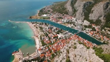 Deniz kıyısındaki Omis kasabasının havadan görünüşü ve Cetina nehrinin akışı. Hırvatistan 'da yaz tatili..