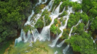 Tropik orman ve dağ manzarası. Su ve şelalelerden oluşan akarsular. İlkbahar ya da yaz aylarında şelaleler yemyeşil alanlar arasında akar. Plitvice Lakes Ulusal Parkı Hırvatistan. Seyahat ve doğa kavramı.