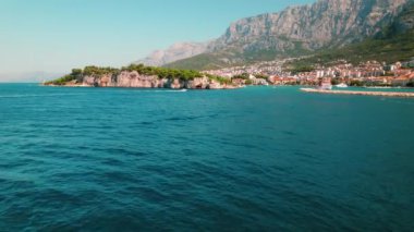 Orman burnu üzerinde tarihi bir deniz feneri olan sakin bir okyanus manzarası. Hırvatistan 'da yaz deniz manzarası. Popüler turizm merkezi..