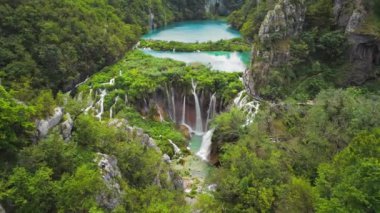 Güçlü şelale masmavi berrak suyla bir göle akar. Hırvatistan 'daki Plitvice Lakes Ulusal Parkı. Şelaleler ve kireçtaşı kanyonuyla birbirine bağlı 16 gölden oluşan bir şelale. Hava görünümü.