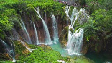 Güçlü şelale masmavi berrak suyla bir göle akar. Hırvatistan 'daki Plitvice Lakes Ulusal Parkı. Şelaleler ve kireçtaşı kanyonuyla birbirine bağlı 16 gölden oluşan bir şelale. Hava görünümü.