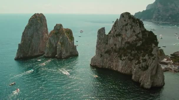 画龙点睛的海拱形雕刻在被大海高耸的悬崖峭壁上 天然的桥梁为船只提供了一个门户 意大利卡普里的Faraglioni海运堆栈 — 图库视频影像