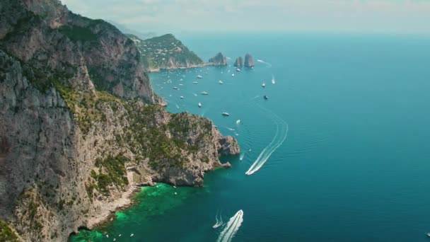 在空中俯瞰着卡普里岛和生机勃勃的蓝色海水 充满了船只和生命 著名的Faraglioni三个岩层 — 图库视频影像