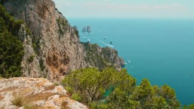 Capri 'nin nefes kesen Faraglioni kayalıkları, Tyrhenian Denizi' ne bakıyor. Ufuk çizgisini noktalayan teknelerle...