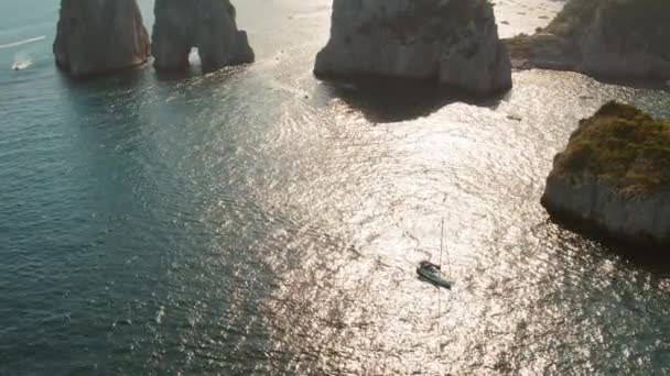 Лодка Плывет Через Солнечные Воды Между Драматическими Скальными Образованиями Капри — стоковое видео