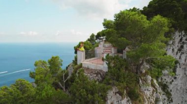 Capri 'nin uçurumundaki terastan manzaranın keyfini çıkaran kişi. Denizin üzerinde meditasyon yapan bir kadın kayalık çıkıntıda..