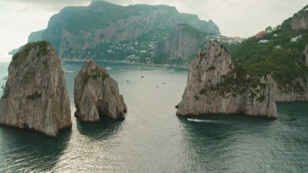 海景与岩石悬崖法拉格里奥尼和豪华游艇漂浮在远方 意大利卡普里岛附近游船的空中景观 — 图库视频影像