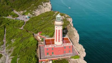 Deniz feneriyle kaplı Capri kıyı şeridine bakan güvenli geçiş sembolü olarak duruyor. Faro di Punta Carena 'nın İtalya' daki hava manzarası..