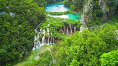 Plitvice Gölleri Ulusal Parkı Hırvatistan 'da yürüyüş yapan insanlar. Bir sürü su ve şelalesi olan dağ manzarası. Seyahat ve doğa kavramı.