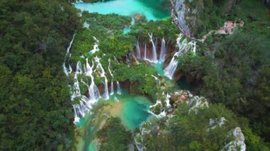 Güçlü şelale masmavi berrak suyla bir göle akar. Hırvatistan 'daki Plitvice Lakes Ulusal Parkı. Şelaleler ve kireçtaşı kanyonuyla birbirine bağlı 16 gölden oluşan bir şelale. Hava görünümü.