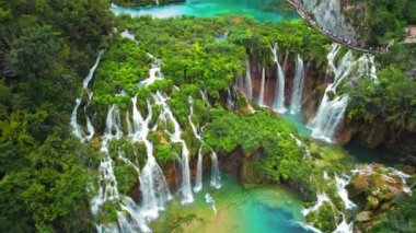 Güçlü şelale masmavi berrak suyla bir göle akar. Hırvatistan 'daki Plitvice Lakes Ulusal Parkı. Şelaleler ve kireçtaşı kanyonuyla birbirine bağlı 16 gölden oluşan bir şelale. Hava görünümü.