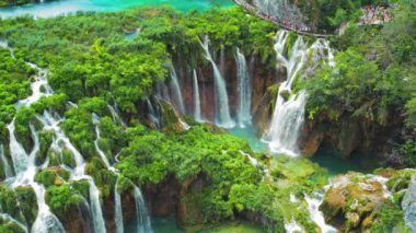 Güçlü şelale masmavi berrak suyla bir göle akar. Hırvatistan 'daki Plitvice Lakes Ulusal Parkı. Şelaleler ve kireçtaşı kanyonuyla birbirine bağlı 16 gölden oluşan bir şelale. Hava görünümü.