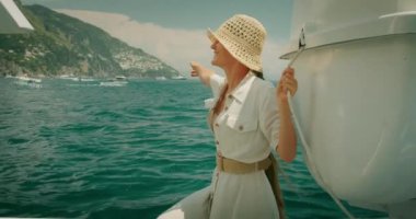 Gezgin gemiyle Akdeniz 'e ulaşıyor. Neşeli kadın yaz güneşli bir günde hafif esintiden hoşlanıyor. Capri Adası, İtalya gezisi..