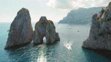 Capri 'nin ikonik Faraglioni kayaları gök mavisi deniz sularıyla çevrili. İtalya 'da deniz manzarası var. Stacks Stella, Mezzo, Fuori..