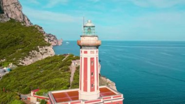 Huzurlu bir okyanus zeminli kırmızı deniz fenerinin yakın çekimi. Faro di Punta Carena 'nın İtalya' nın Capri adasındaki hava manzarası..