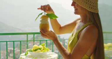 Keyifli bir kadın elinde kremalı dondurma ya da şerbetli limon tutar Amalfi sahili yaz arkaplanına karşı..