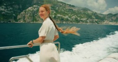 Sakin kız, Amalfi sahilinin arka planına karşı. İtalya 'nın engebeli uçurumları boyunca yelken açıyorlar. Yaz deniz yolculuğuna çıkmış bir kadın...