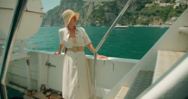 Beyaz elbiseli kadın Positano deniz manzarasına bakıyor. Manzaralı İtalyan sahili. Gezgin, eğlence gemilerinin ortasındaki Tyrhenian Denizi 'nin panoramik manzarasının tadını çıkarıyor...