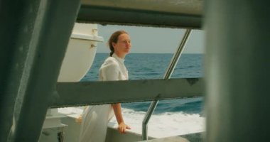 Uçsuz bucaksız denizi arayan bir kadın, öğlen güneşinden gözlerini ayırıyor. Uzağa bakarak, deniz ufkunun ötesinde yatanları arıyor...