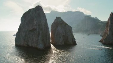 Capri 'nin Faraglioni kayaları parıldayan denizin üzerinde gezginler ve doğa meraklıları için bir yol gösterici. Yaz deniz manzarası..