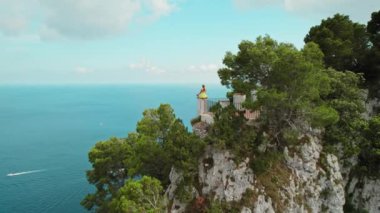 Kadın kayalık kayalıklarda meditasyon yapıyor. Capri Adası 'nın deniz manzarası nefes kesici...