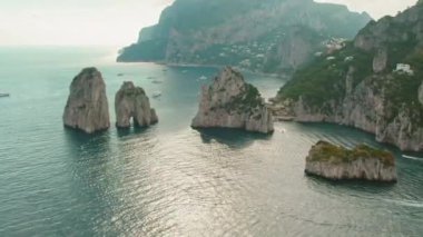 Capri sahil şeridindeki Faraglioni kayalarının manzarası. Dünyaca ünlü deniz yığınlarının havadan görünüşü. Yaz İtalya manzarası..