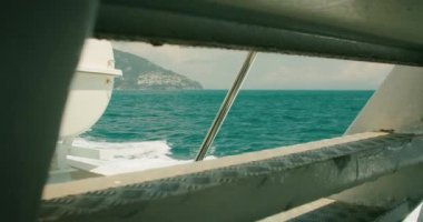 Capri 'nin sakin mavi suları ve bir teknenin kenarındaki sahil şeridi, sakin yaz gezisi...