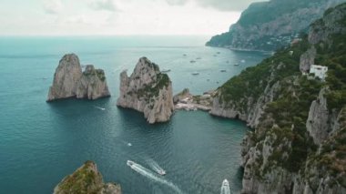 Capri kıyı şeridi boyunca uzanan Coastal Elegance. Tekneler durgun masmavi denizde süzülür. Faraglioni kayalıklarının yanında su sanatı geçidi..