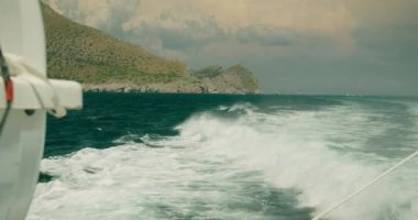 Bir yaz gezisinde Capri kıyı şeridi ve deniz spreyi olan bir yatın pruvası...