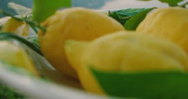 Bir kase olgun limon, deniz ve dağ zeminine karşı. Canlı, taze ürün, bolluk hissi ve kıyı manzaralı doğal güzellik...