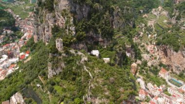 Atrani ile Amalfi kasabası arasındaki hava manzaralı renkli binalar ve yaz güneşli bir günde yemyeşil alanlar...