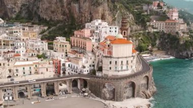 Atrani şehri, yaz boyunca İtalya 'nın Amalfi kıyısında kayalıklarda ve Akdeniz kıyısında binalar gösteriyor..
